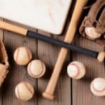 Various used baseball equipment on a wooden surface.