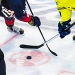 A hockey game about to start with hockey sticks on the ready.