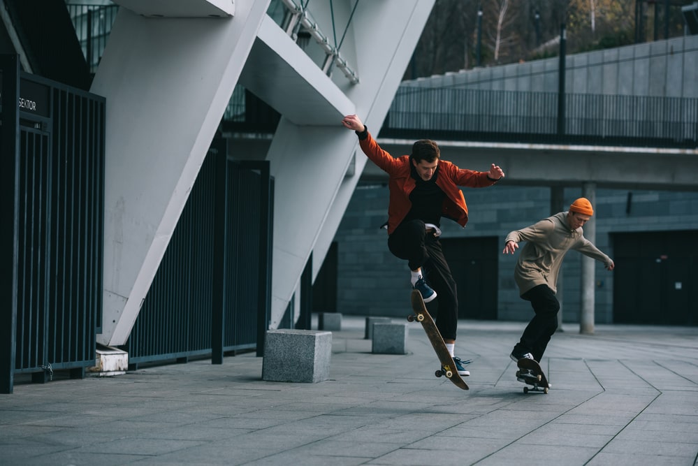 Two guys skateboarding in an urban location, wearing their high-quality skateboarding shoes and apparel.
